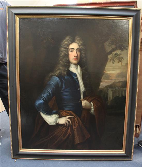 Thomas Gibson (1680-1751) Portrait of a gentleman standing in a landscape, a country house beyond, 50 x 40in.